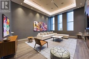 Toronto (Waterfront Communities) condo for rent - A modern living room with a large painting on the wall and a white sofa.