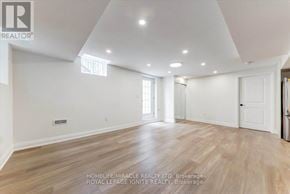 Pickering apartment for rent - A spacious room with wooden flooring and white walls.