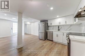 Pickering apartment for rent - A spacious kitchen with white cabinets and a wooden floor.