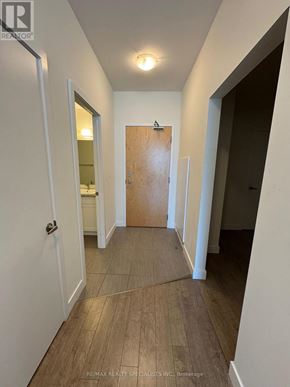 Kitchener condo for rent - A hallway with a wooden floor and white walls.