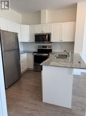 Kitchener condo for rent - A kitchen with white cabinets and a granite countertop.