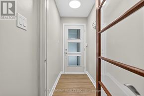 Ottawa apartment for rent - A hallway with a white door and a wooden floor.