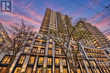 Toronto (Forest Hill South) condo for rent - A parking lot with cars and buildings in the background.