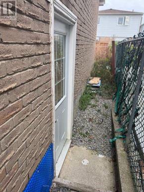 Brampton (Fletcher's West) apartment for rent - A white door is on a brick wall with a black fence and a blue mat in front of it.