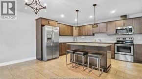 Lasalle apartment for rent - A kitchen with a refrigerator, stove, and bar stools.