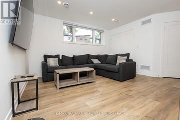Niagara Falls (Downtown) townhouse for rent - A living room with a grey couch and a wooden coffee table.