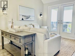 Collingwood condo for rent - A living room with a white couch, a wooden table, and a painting of a boat on the wall.
