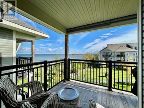Collingwood condo for rent - A balcony with a table and chairs overlooking a grassy area.