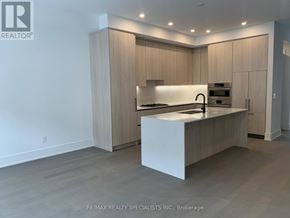 Mississauga (Port Credit) townhouse for rent - A modern kitchen with wooden cabinets and a white island.