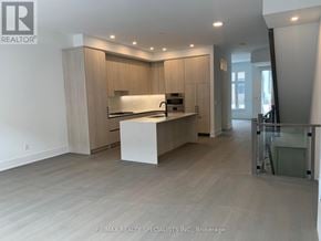 Mississauga (Port Credit) townhouse for rent - A spacious kitchen with wooden cabinets and a white island.