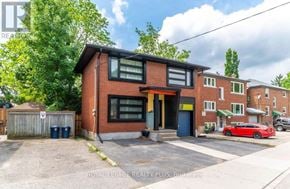 Kitchener multi-family for rent - A red car is parked in front of a brick building.