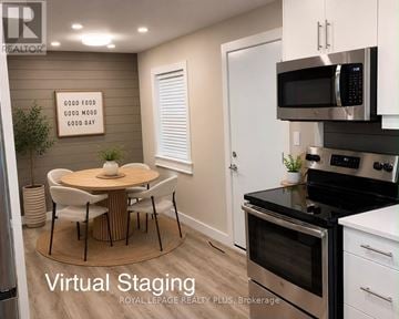 Kitchener multi-family for rent - A modern kitchen with a dining table and chairs, and a sign that says "Good Food Good Mood Good Day".