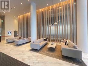 Mississauga (City Centre) condo for rent - A modern waiting area with white furniture and a glass partition.