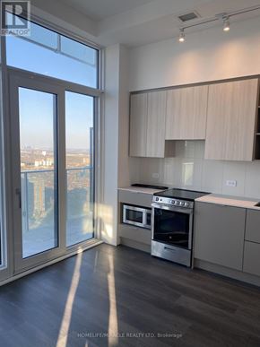 Mississauga (City Centre) condo for rent - A modern kitchen with a view of the city through the windows.