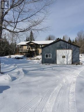 Marmora And Lake (Marmora Ward) apartment for rent - A house with a garage is surrounded by snow.