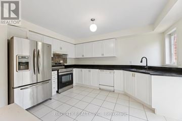 Ajax (South East) apartment for rent - A white kitchen with a black counter top and a refrigerator with a water dispenser.