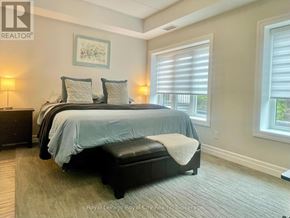 Centre Wellington (Elora/Salem) condo for rent - A bedroom with a bed, nightstand, and window.