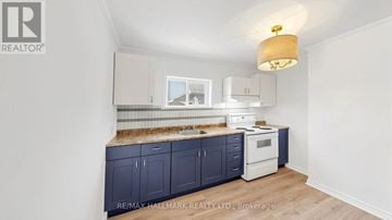 Kawartha Lakes (Lindsay) multi-family for rent - A kitchen with dark blue cabinets and a white oven.