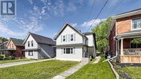 Kawartha Lakes (Lindsay) multi-family for rent - A white house with a grey roof is surrounded by other houses.