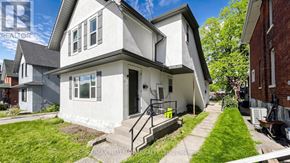 Kawartha Lakes (Lindsay) multi-family for rent - A white house with a black roof and a small porch.
