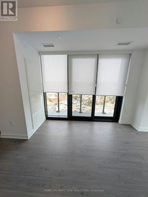 Kitchener condo for rent - A room with a view of a cityscape through the windows.