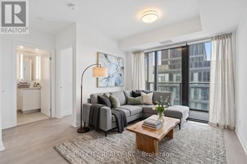Toronto (Leaside) condo for rent - A well-lit living room with a grey sofa and a coffee table.