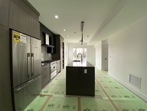 Surrey townhouse for rent - A kitchen with a black island in the middle of a hallway.