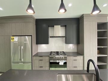 Surrey townhouse for rent - A modern kitchen with a stainless steel sink and a stove top oven.
