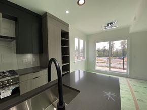 Surrey townhouse for rent - A modern kitchen with a stainless steel sink and black cabinets.