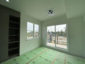 Surrey townhouse for rent - A room with a large window and a view of a construction site outside.