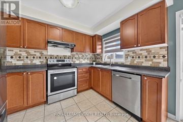 Ajax (Northwest Ajax) townhouse for rent - A kitchen with brown cabinets and a tiled backsplash.