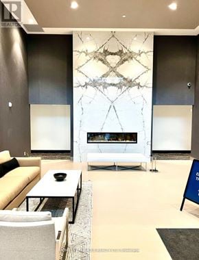 Milton (Walker) condo for rent - A modern living room with a white sofa, a coffee table, and a fireplace with a marble backdrop.