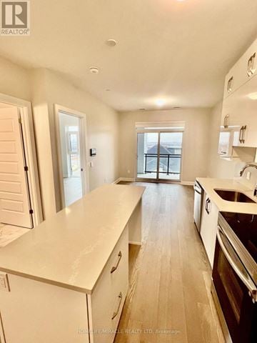 Milton (Walker) condo for rent - A kitchen with white cabinets and a wooden floor.