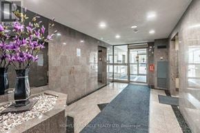 Brampton (Fletcher's Creek South) condo for rent - A hallway with a blue carpet and a vase of purple flowers on the left.