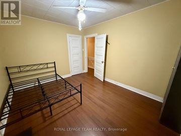 Ottawa apartment for rent - A bedroom with a bed, dresser, and ceiling fan.