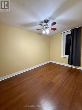 Ottawa apartment for rent - A room with a ceiling fan and wooden flooring.