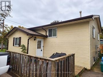 Orillia apartment for rent - A beige house with a white door and a small window.