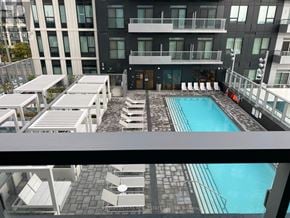 Vaughan (Vaughan Corporate Centre) condo for rent - A pool area with sun loungers and a building in the background.