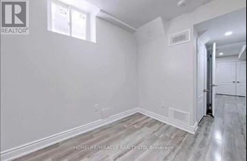 Brampton (Northwood Park) apartment for rent - A room with white walls and wooden flooring, with a door on the right side.
