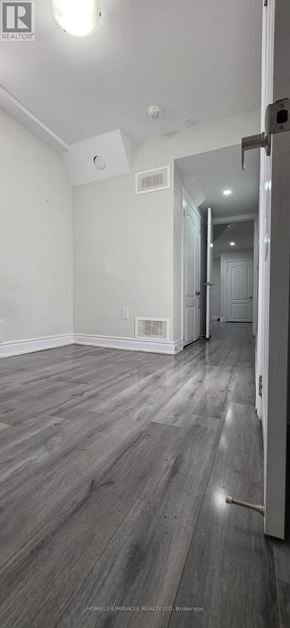 Brampton (Northwood Park) apartment for rent - A room with a white wall and a wooden floor.