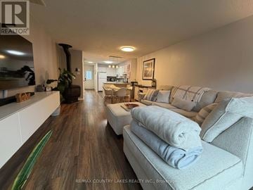 Ramara townhouse for rent - A living room with a grey couch and a wooden floor.