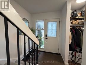 Ramara townhouse for rent - A hallway with a white door and a window, leading to a balcony.