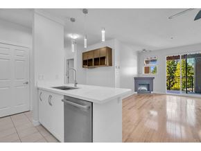 Surrey apartment for rent - A modern kitchen with white cabinets and a wooden hood.