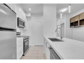 Surrey apartment for rent - A modern kitchen with white cabinets and stainless steel appliances.