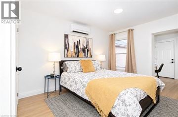 Hamilton apartment for rent - A bedroom with a bed, two lamps, and a painting on the wall.