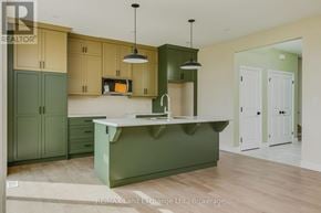 Saugeen Shores apartment for rent - A kitchen with green cabinets and a white counter.