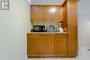 Brampton (Fletcher's West) apartment for rent - A kitchen with wooden cabinets and appliances on a counter.