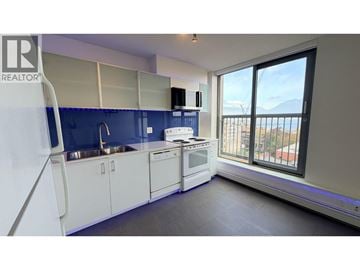Vancouver apartment for rent - A kitchen with white cabinets and a blue backsplash.