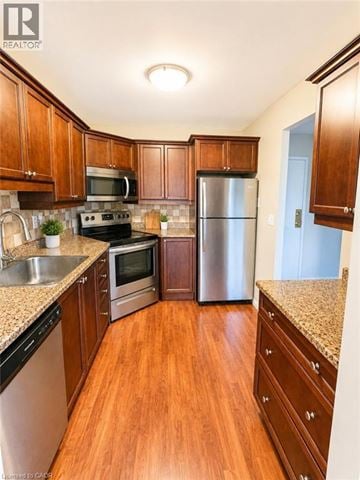 Kitchener condo for rent - A kitchen with wooden cabinets and a stainless steel refrigerator.