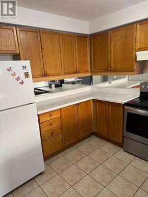 Brampton (Fletcher's Meadow) apartment for rent - A kitchen with wooden cabinets and a white fridge.